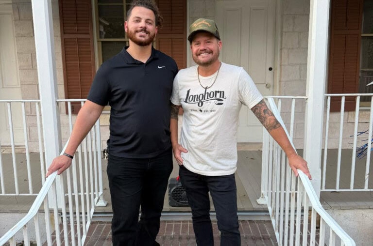 Graphic of two men standing on front porch of a house with white railing and brick steps.