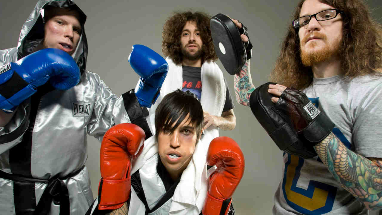 Fall Out Boy posing for a photograph wearing boxing gloves in 2008