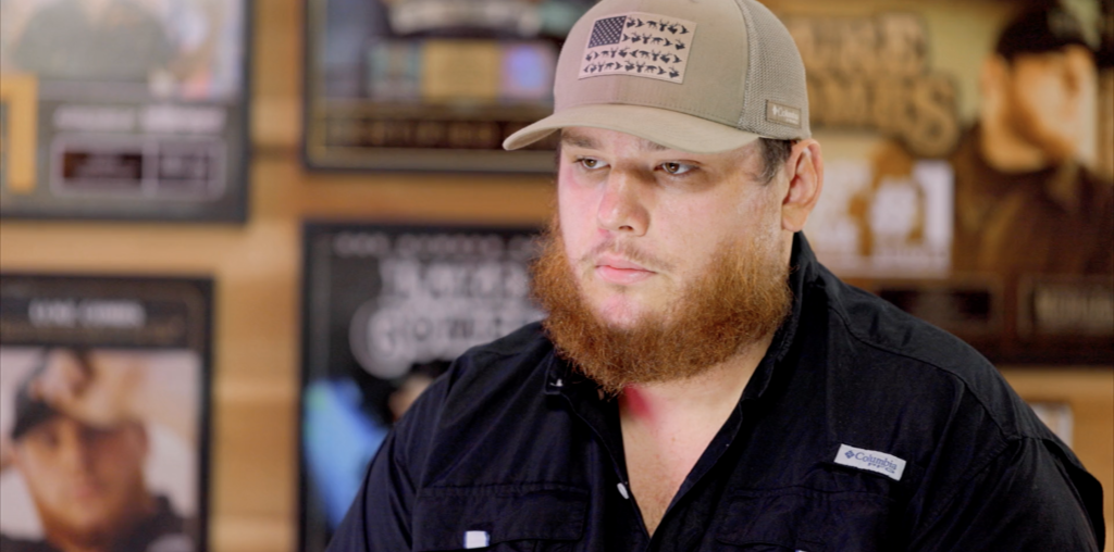 Sports fan with beard wearing baseball cap at Hall of Fans memorabilia store.
