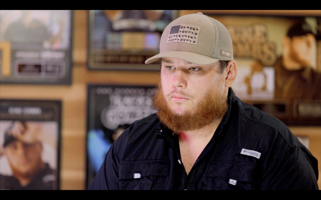 Sports fan with beard wearing baseball cap at Hall of Fans memorabilia store.