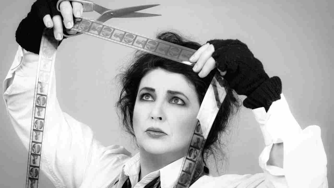 Kate Bush posing for a photo with a film reel and scissors
