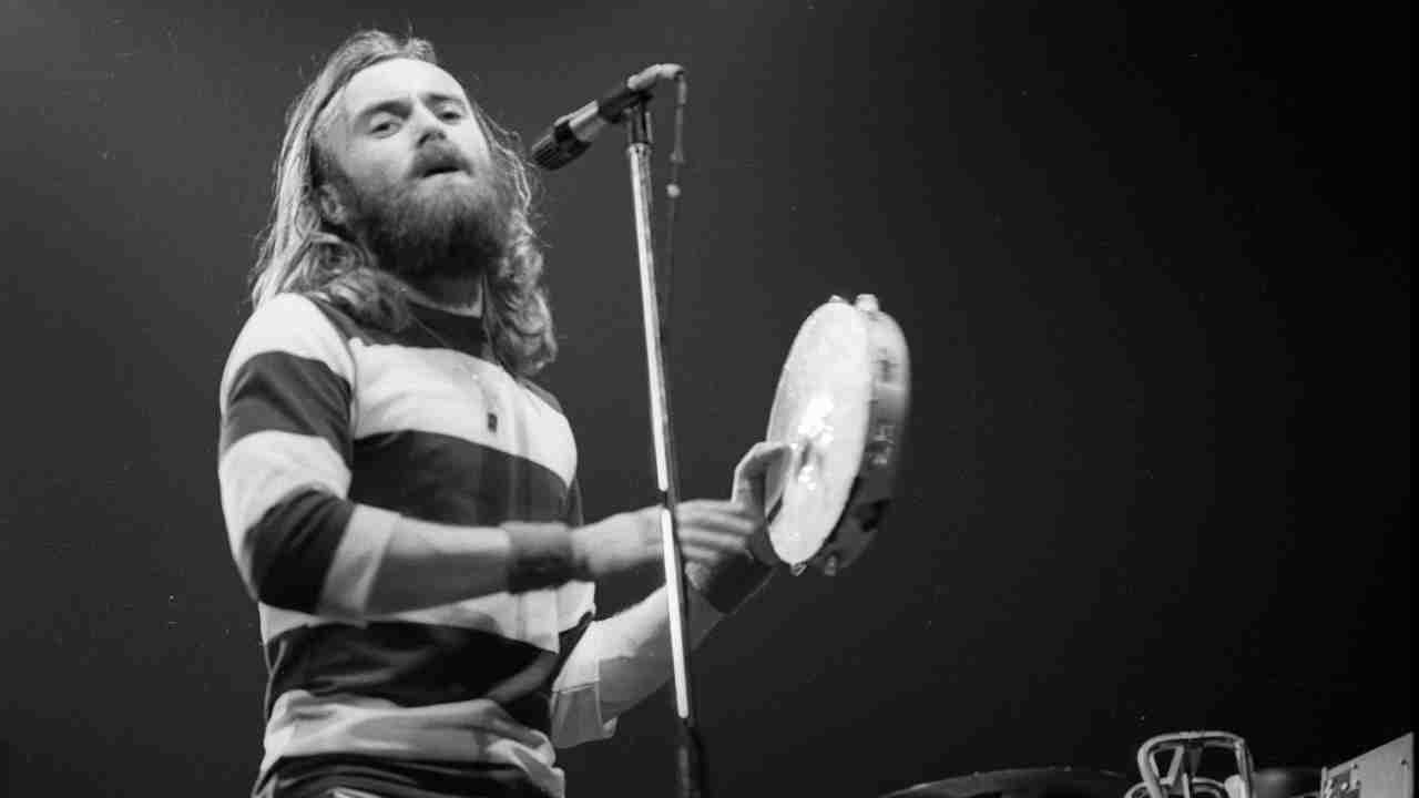 Phil Collins playing tambourine at a gig in 1977