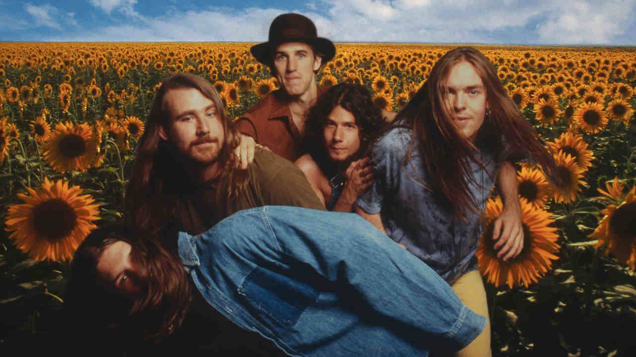 Blind Melon posing for a photograph in a field of sunflowers in the 1990s