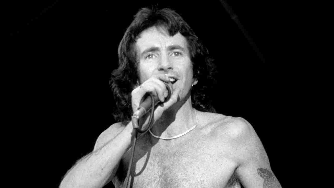 Bon Scott performing onstage with AC/DC