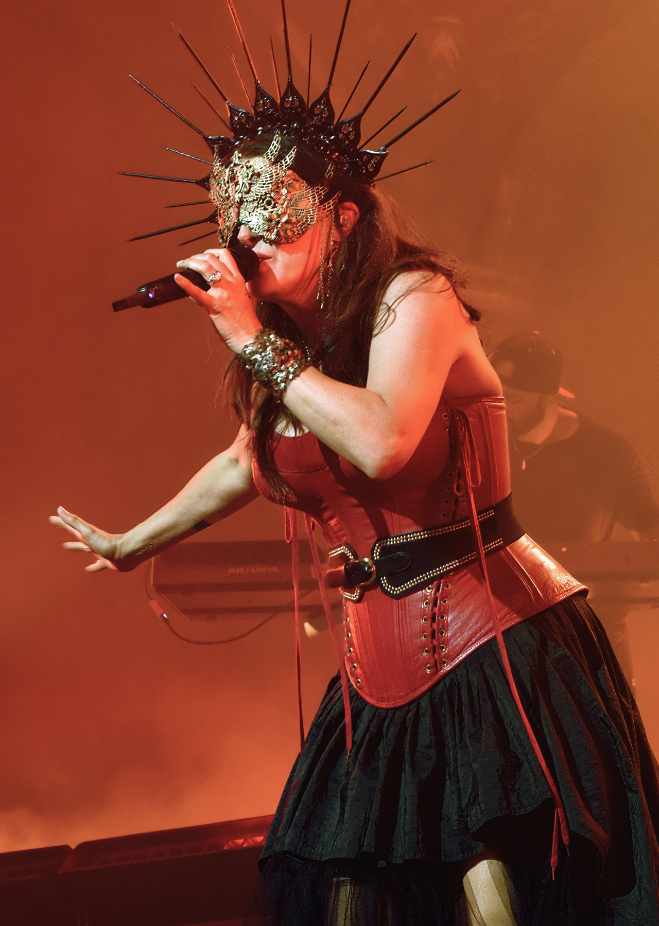 Sharon den Adel on stage in a striking spiky headdress and mask