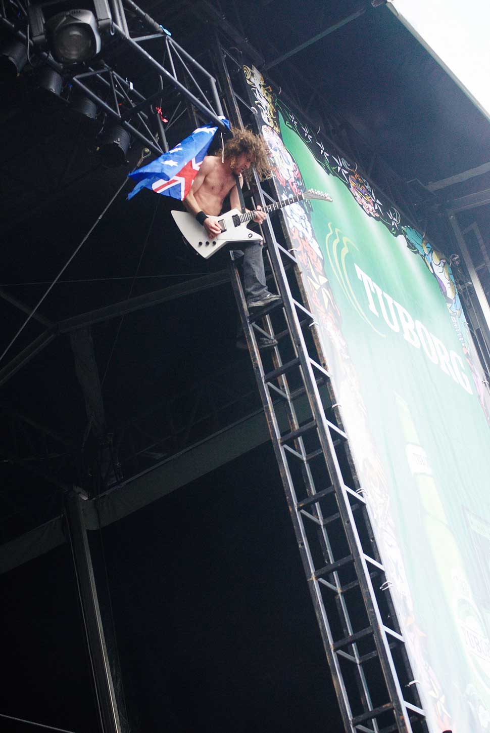 Joel O'Keefe climbing the stage with an Australian flag
